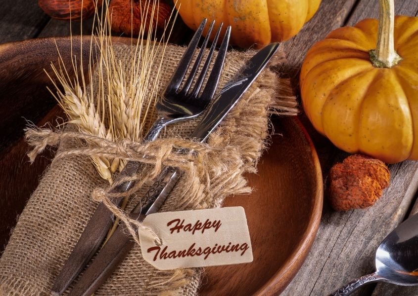 rustic dining table with pumpkins and string tied around knife and fork and rustic napkin