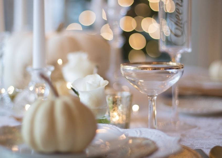 white pumpkin and champagne glass on wooden dining table