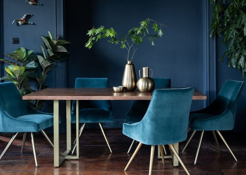 mango wood dining table with brass metal legs and blue velvet dining chairs