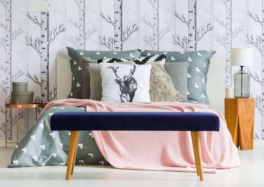 Purple velvet foot stool and large king size bed with grey headboard