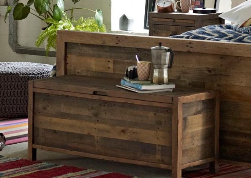 Reclaimed wood blanket box next to wooden bed frame