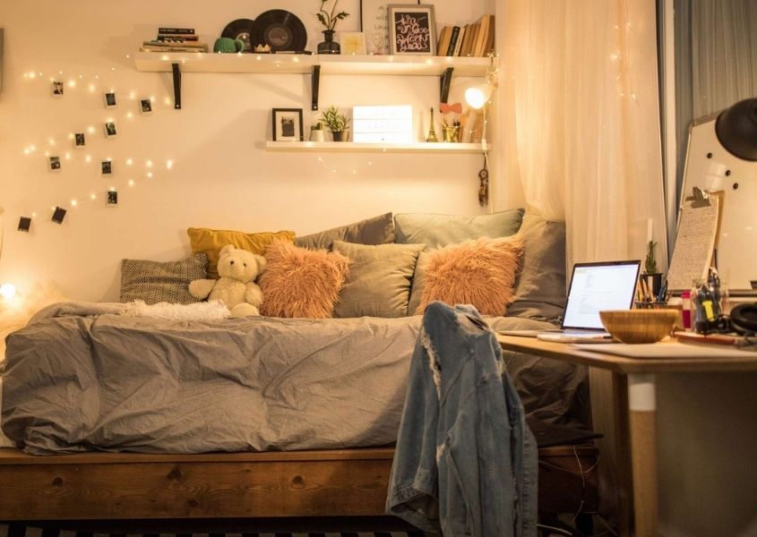 child's bedroom with wooden desk, single bed and hanging fairy lights