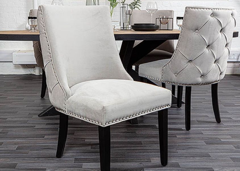 grey upholstered dining chair with button studded back and black wooden legs