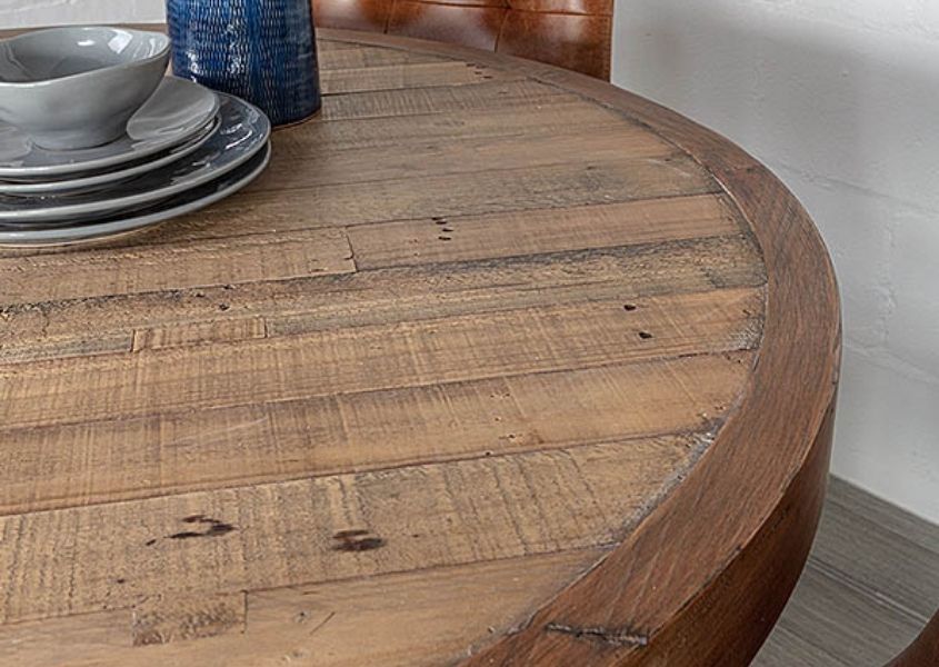 Close up of round reclaimed wood dining table and blue bowl