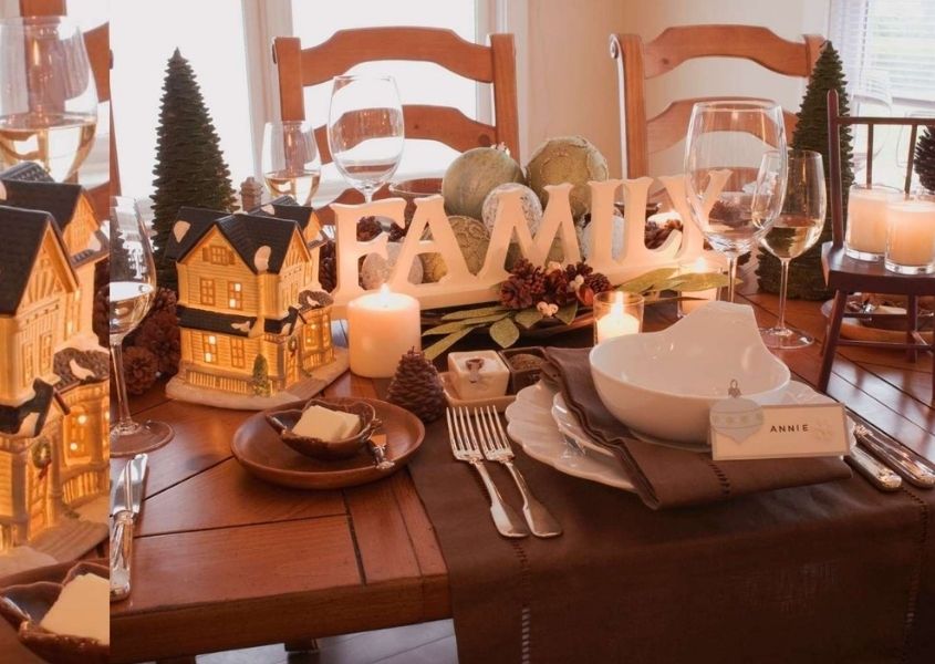 Wooden dining table decorated with christmas decorations and wooden sign spelling family