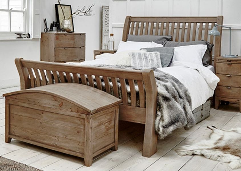 Bedroom with reclaimed wood bed and faux fur covers with wooden blanket box