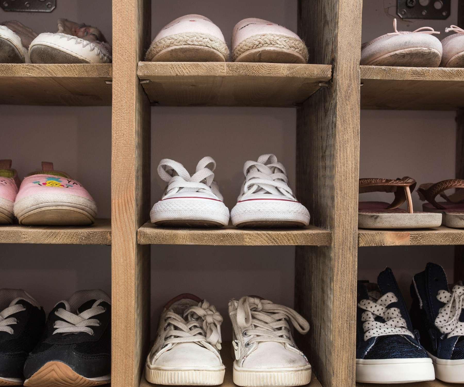 wooden shoe storage unit with shoes in it